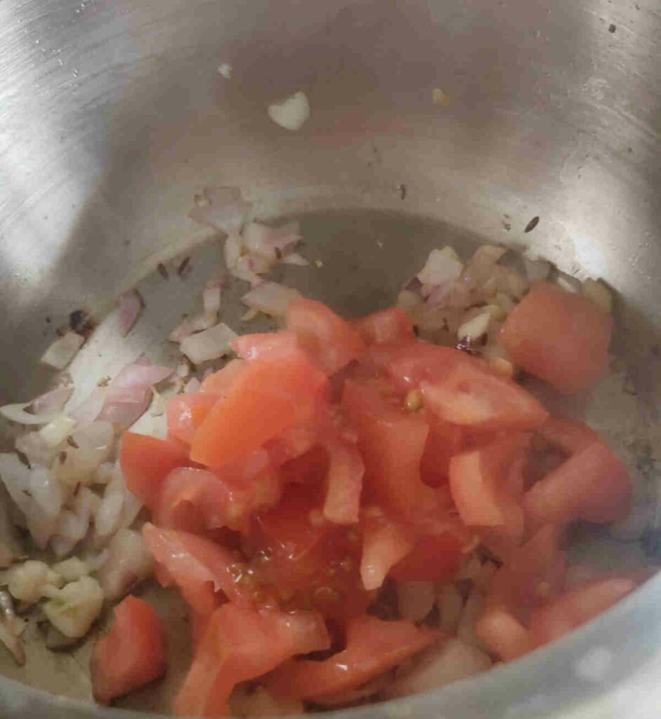 add tomatoes to cooked onions for red lentil soup