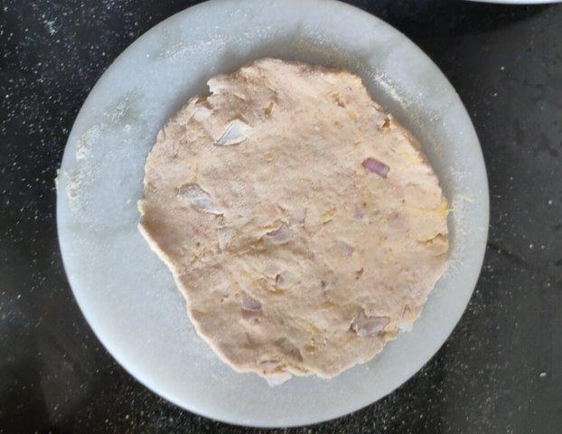 rolled dough using rolling pin for pumpkin paratha