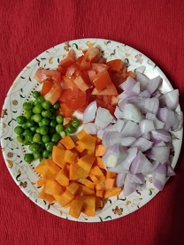 chopped fresh vegetables (onion, carrots, tomato, peas) for vegetable rice