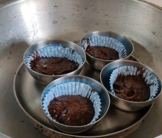 place small bowls with cup cake and batter in wok over a plate 