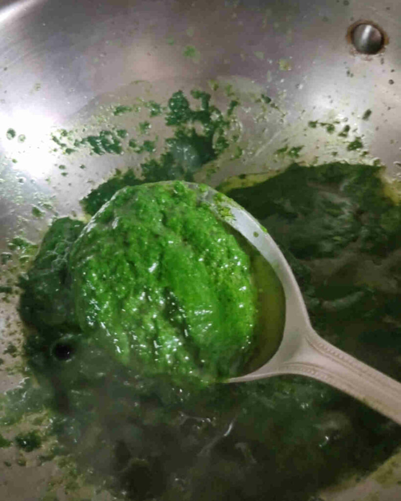 cooking spinach garlic paste in olive oil in wok