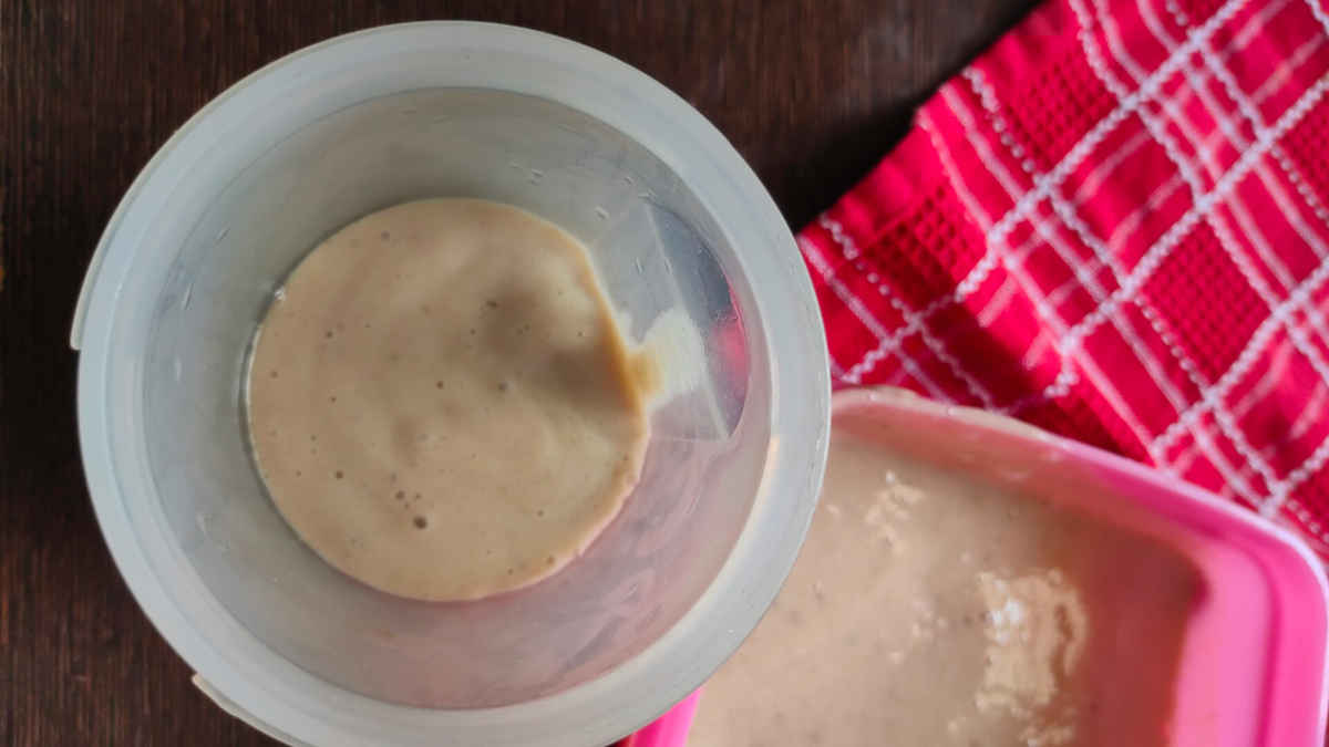 pour banana puree in plastic container with lid for freezing