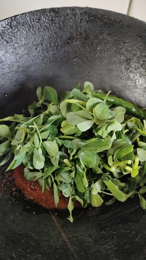 methi added to spices in a wok