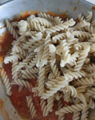 adding boiled pasta in sauce