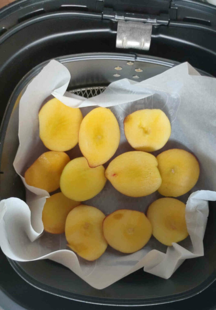 place chopped peaches in air fryer basket over parchment paper