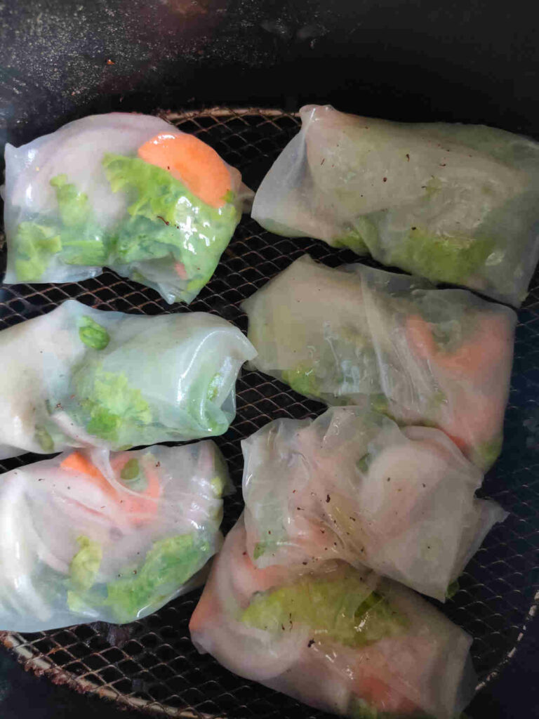 place the greased rice paper rolls in air fryer basket for frying