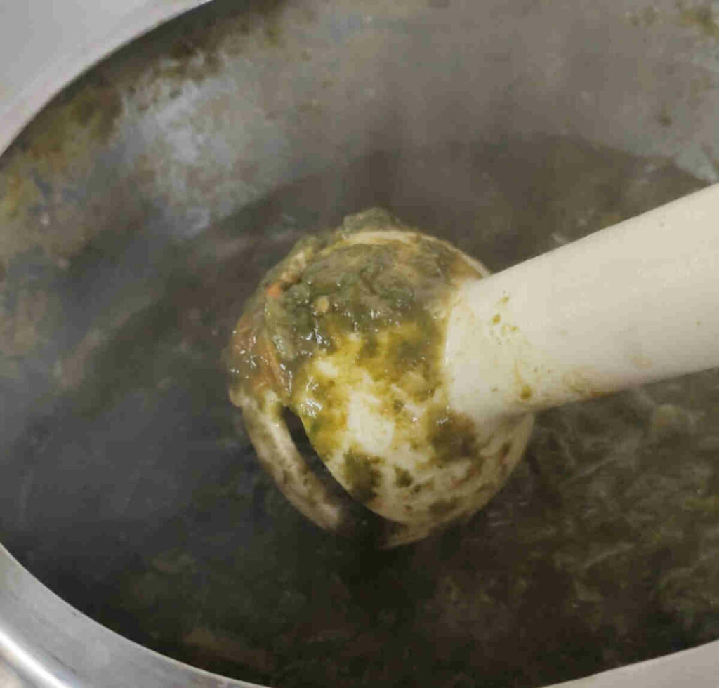 blending the spinach curry with hand blender for saag paneer