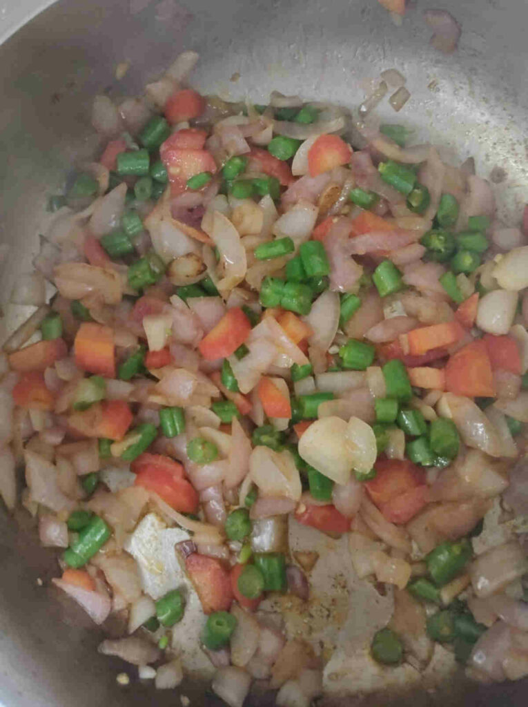 add veggies to cooked onions for making fried rice