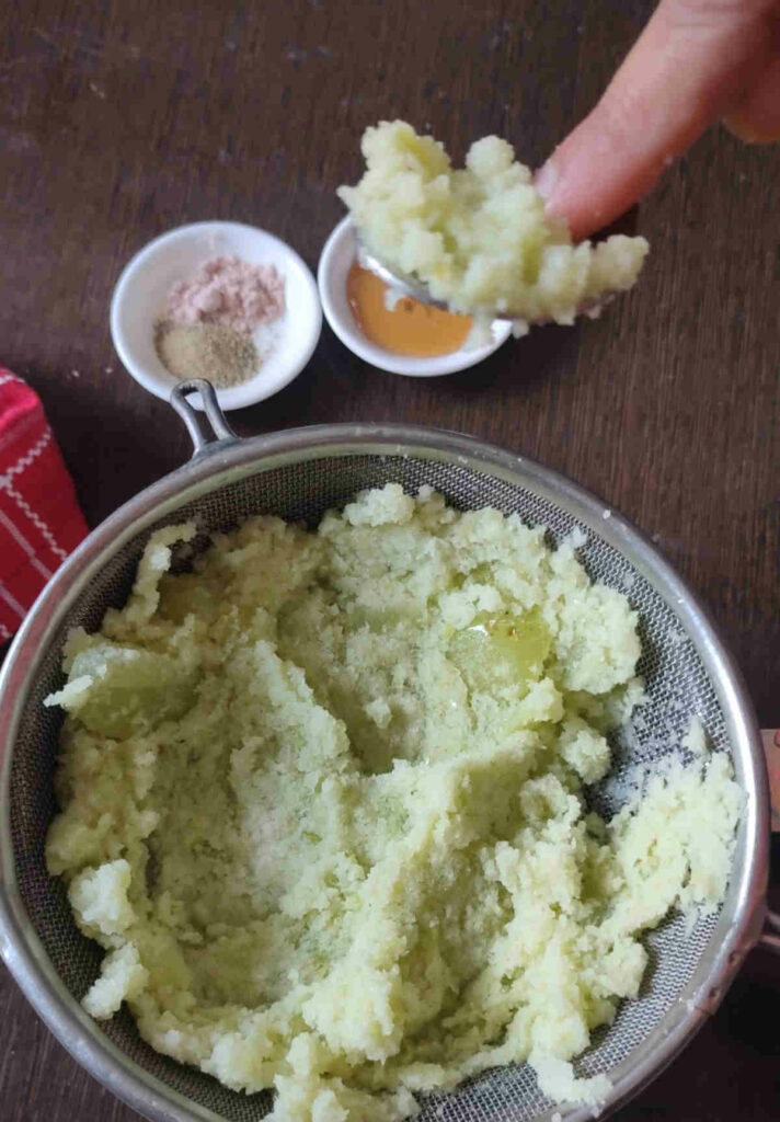 press the amla paste with back of spoon to squeeze the juice